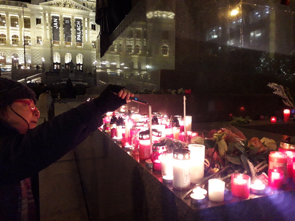 Eine Frau entfacht eine Kerze für Jan Palach und Jan Zajíc. Beide zündeten sich vor 50 Jahren auf dem Wenzelsplatz an.